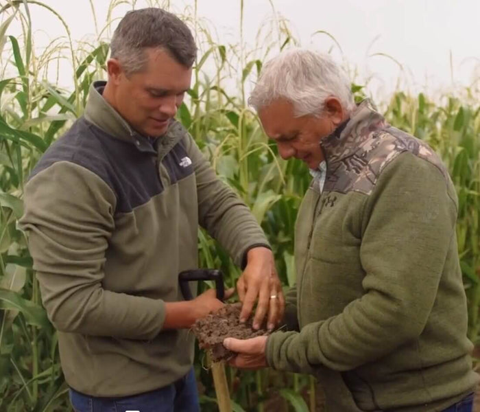 Jordan Carlson and his father, Keith, investigate soil from their crop fields.